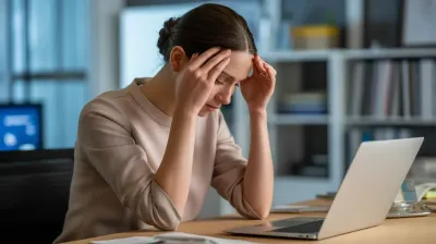 Mulher exausta em frente ao computador, representando a Síndrome da Mulher Maravilha e o Burnout feminino.